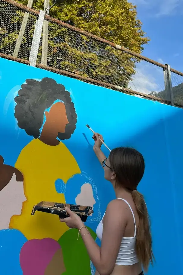 girl doing a wall paintingon page image