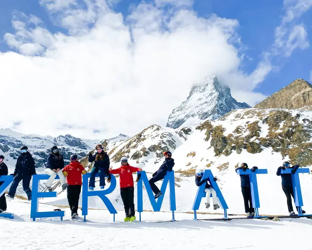 group of students in the mountains at Zermatt lettering