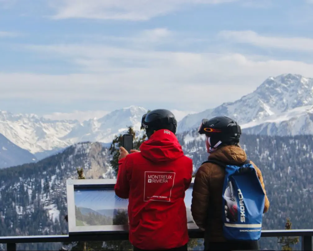 Two participants looking out over the snow-covered mountains