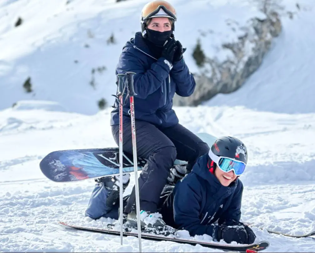 Snowboarders resting on the piste during a winter activity day